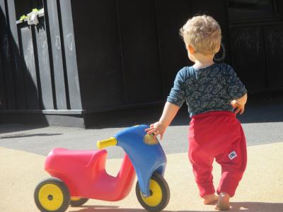 enfant pieds nus de dos, jeu d'enfant à roulettes