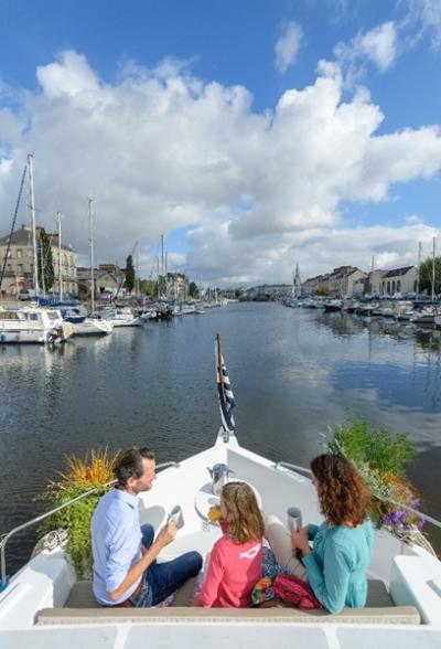 touristes à l'avant d'un bateau navigant, arrivée dans le port de Redon